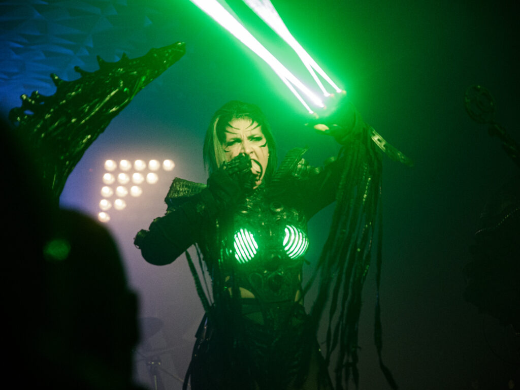 Sick and Beautiful band performing live, the singer is firing lasers from her hands.