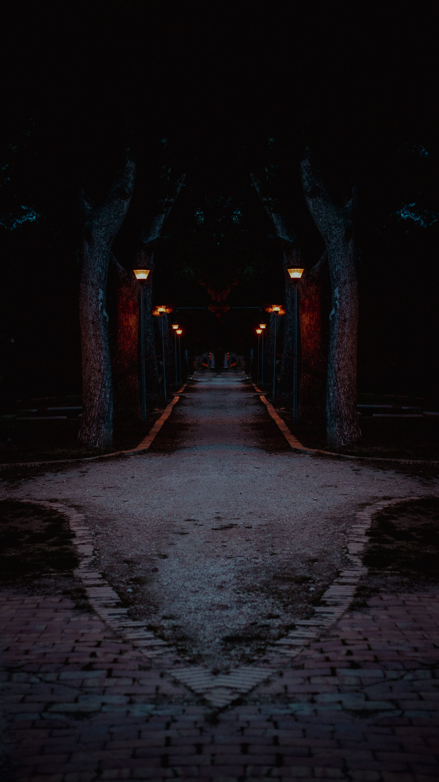 Photograph of a gravel path at night. It ends in a pointed spear-like shape pointing the viewer.