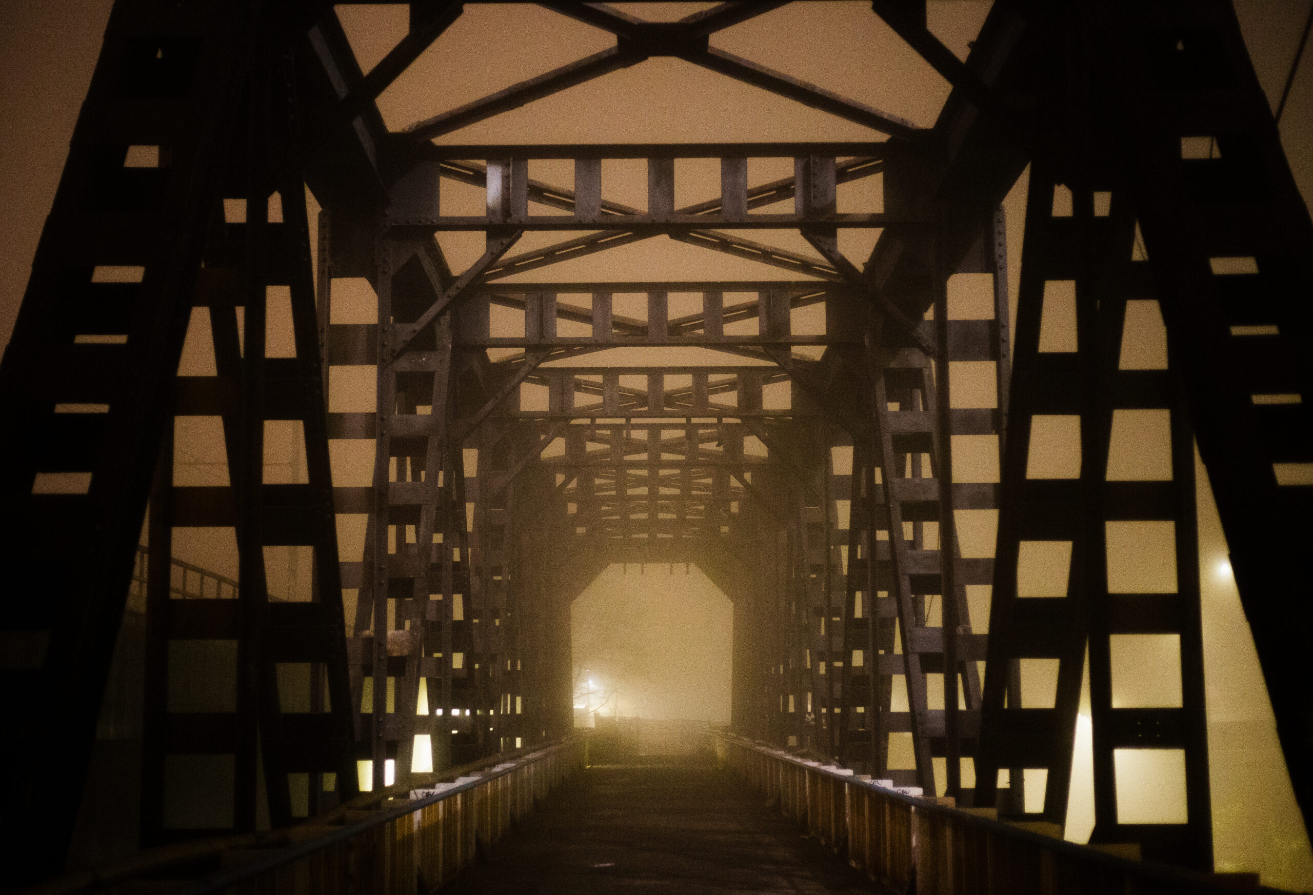 Photograph of an iron bridge shrouded in mist.