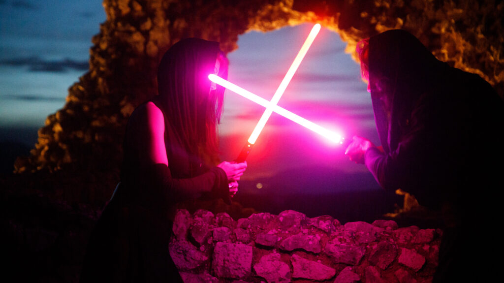Photograph of two Siths fighting each other with lightsabers, at dusk, in the middle of some ruins. From my Star Wars editorial. Unedited.