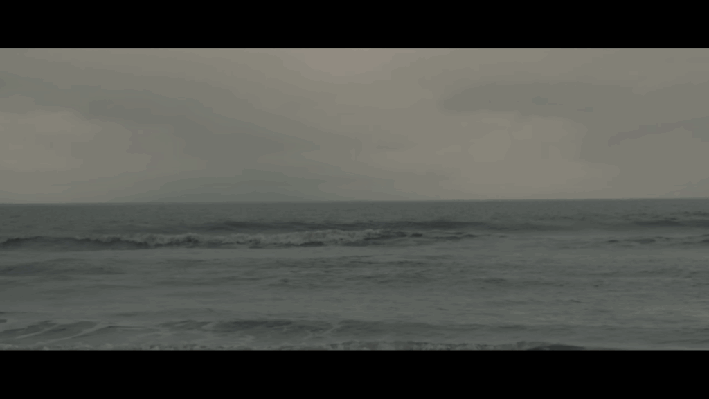 Still from Sleep Token's 'Fall For Me' music video. We see waves and the sky above.